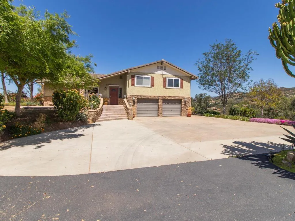 29513 Anthony Road Valley Center, CA 92082 - Photo 7 of 59 a front view of a house with a yard and garage