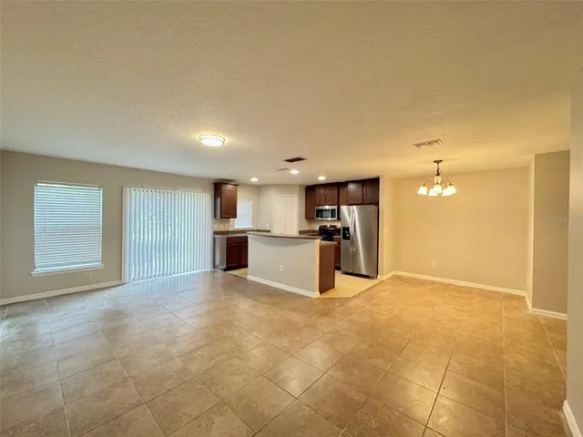 a view of kitchen with kitchen island a sink a stove and white cabinets