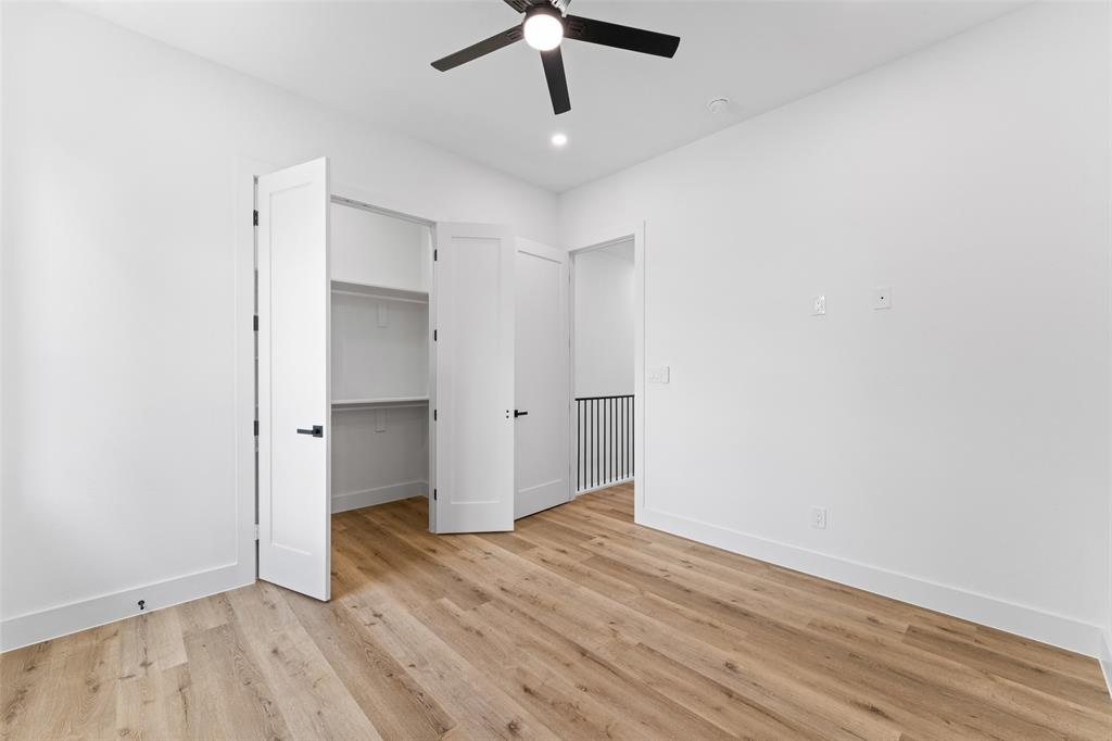 2828 Rochester Street Dallas, TX 75215 - Photo 25 of 36 Unfurnished bedroom featuring a walk in closet, light wood-style floors, and ceiling fan