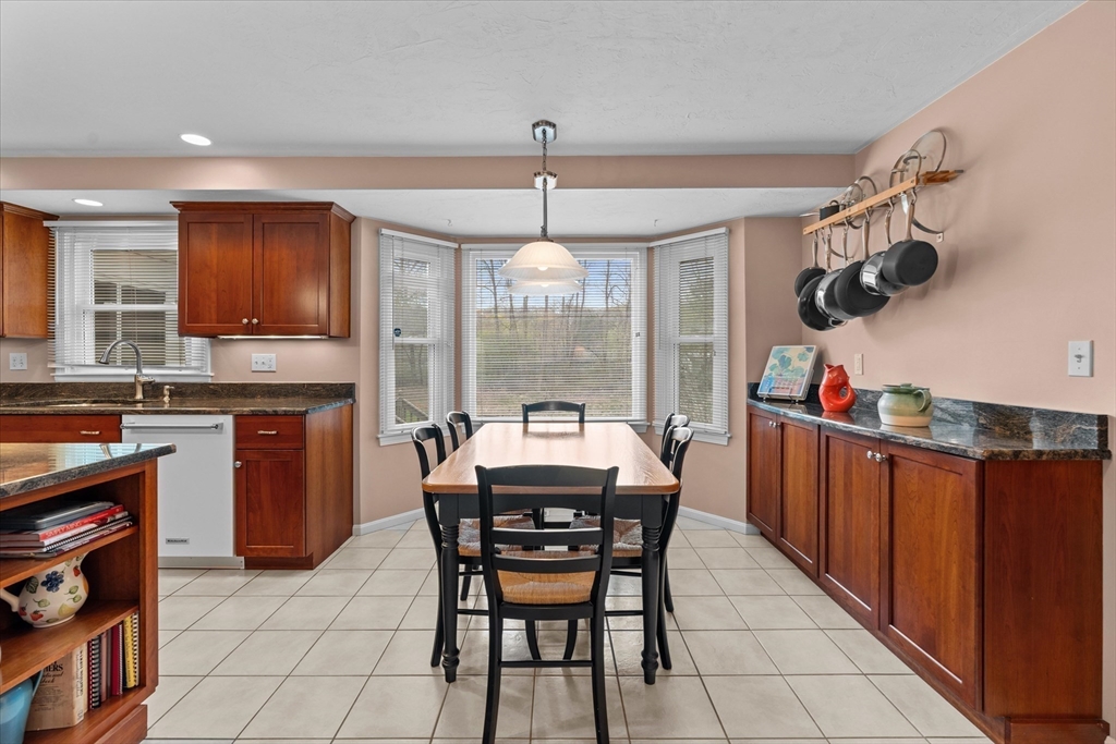 52 Pitt Road Framingham, MA 01701 - Photo 15 of 41 a dining hall with stainless steel appliances granite countertop a stove a sink dishwasher and a dining table with wooden floor