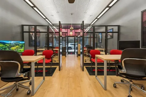 a kitchen with stainless steel appliances granite countertop a sink dishwasher and white cabinets with wooden floor