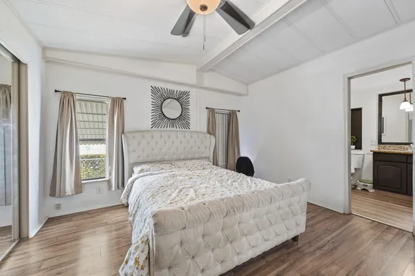a bedroom with a bed and wooden floor