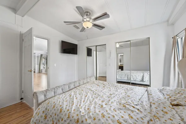 a bedroom with a bed and a large mirror with a flat tv screen