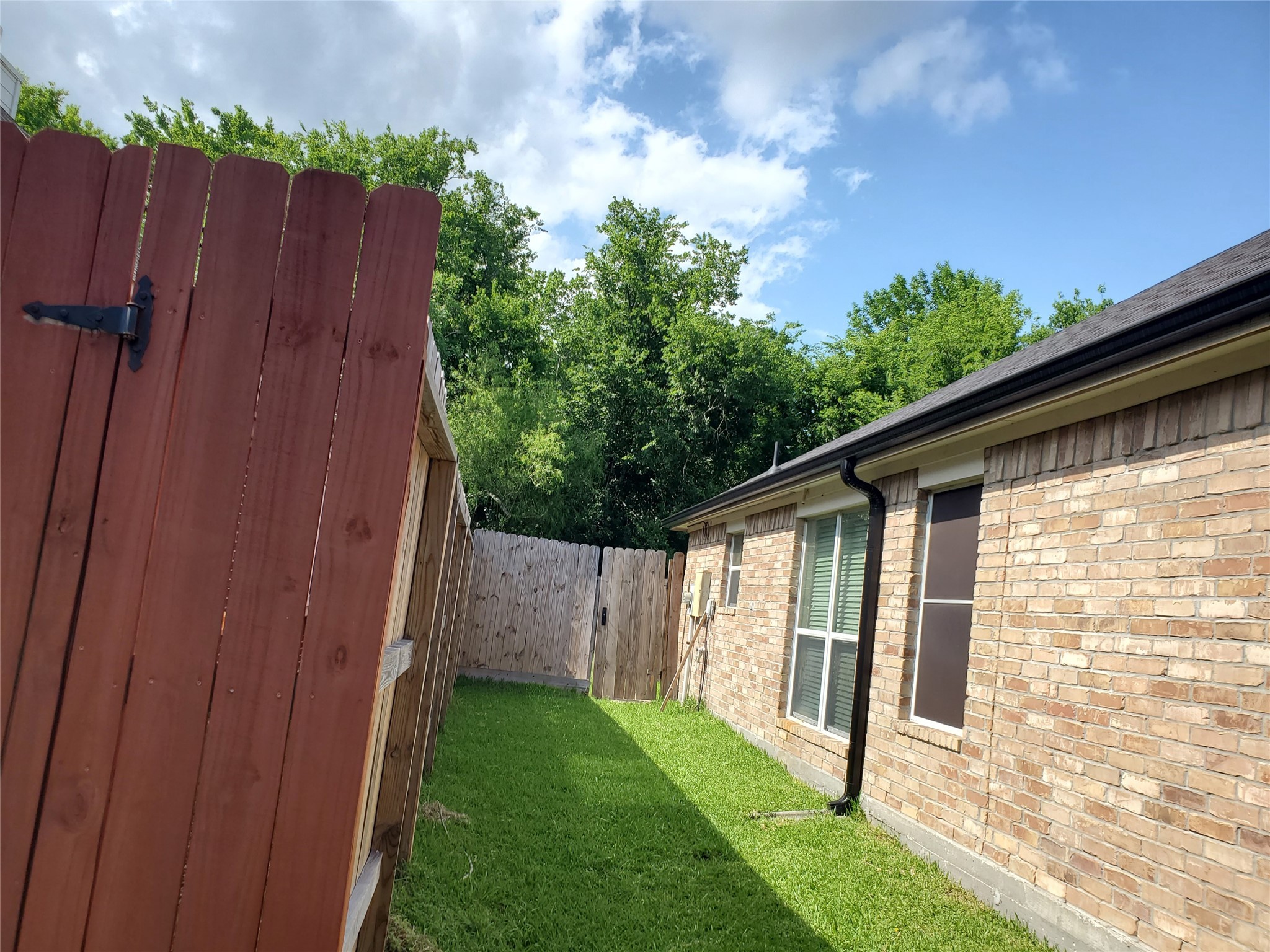 1817 West Cedar Bayou Lynchburg Road Baytown, TX 77521 - Photo 9 of 13 a view of a backyard with wooden fence and large trees