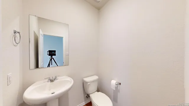 a bathroom with a toilet a sink and mirror