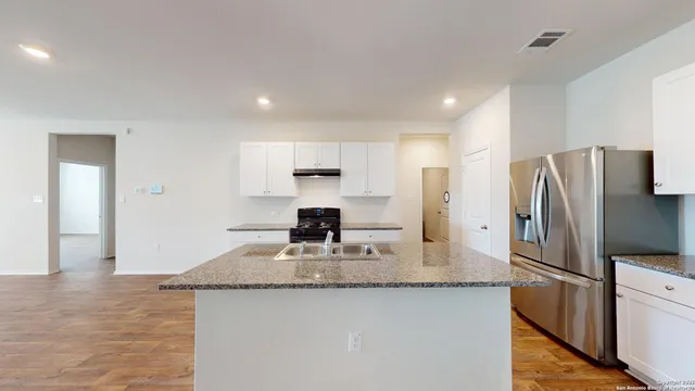 a kitchen with stainless steel appliances granite countertop refrigerator sink and stove