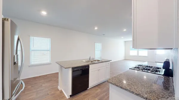 a kitchen with stainless steel appliances granite countertop a sink stove and cabinets