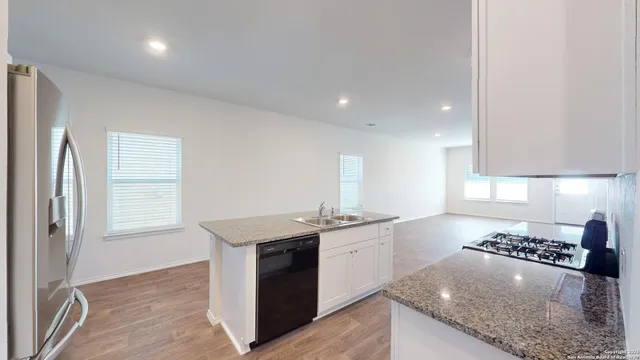a kitchen with stainless steel appliances granite countertop a sink stove and cabinets