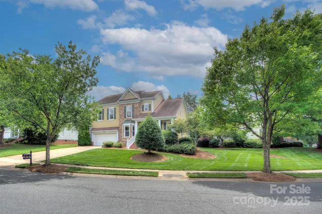 a view of a house with a big yard and large trees