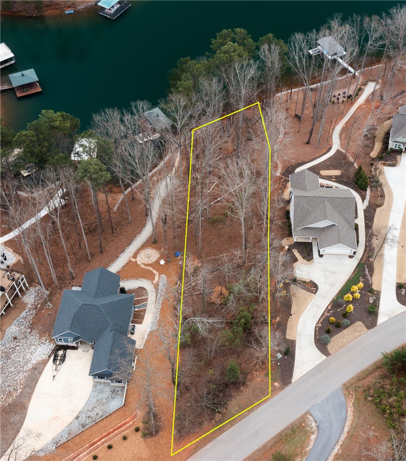 This serene lot offers ample space for building, nestled among mature trees with direct water access.