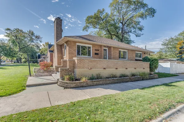 a front view of a house with a yard and potted plants