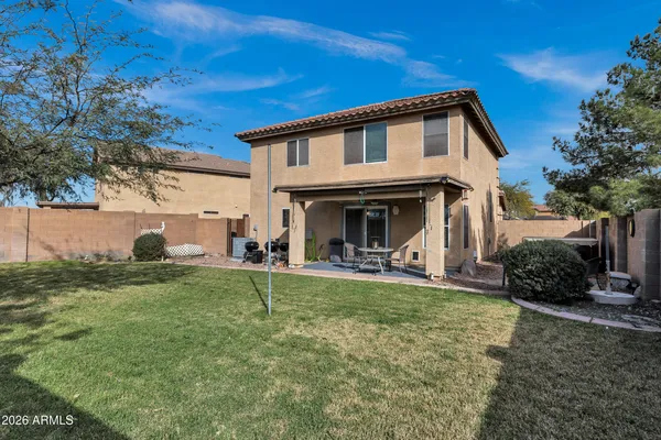 a view of a house with backyard and chairs