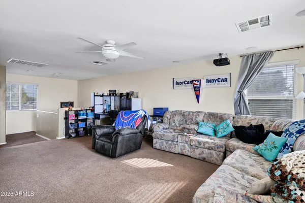 a living room with furniture and a ceiling fan