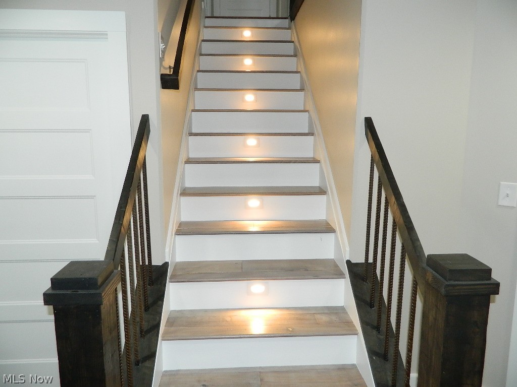 12464 Hotchkiss Road Burton, OH 44021 - Photo 24 of 35 Let's Walk to the Lower Level - Again Such Detail with the Lighted Steps and Custom Railings! Just to the Left of the Staircase is a Separate Unfinished Room and Another Closet Set Up for Another Laundry Room if Wanted.