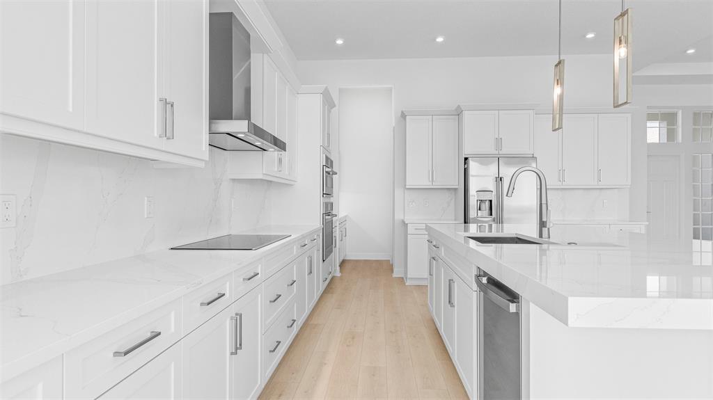 8447 Southwest Felicita Way Port St. Lucie, FL 34987 - Photo 12 of 92 a kitchen with kitchen island white cabinets and stainless steel appliances