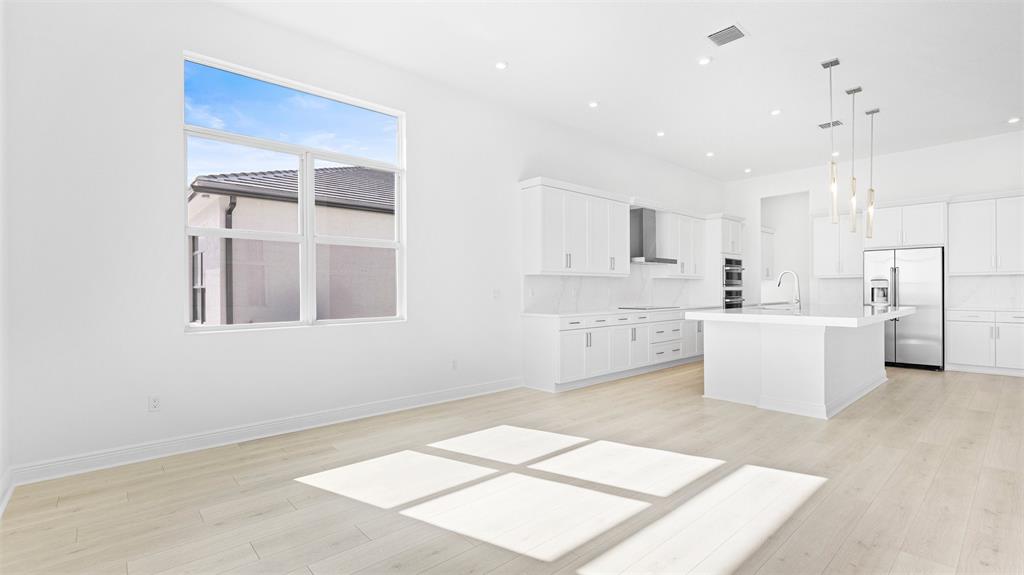 8447 Southwest Felicita Way Port St. Lucie, FL 34987 - Photo 17 of 92 a large white kitchen with cabinets and a window