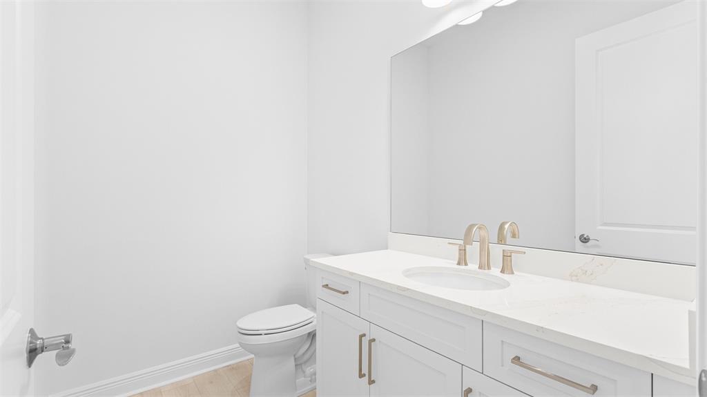 8447 Southwest Felicita Way Port St. Lucie, FL 34987 - Photo 28 of 92 a bathroom with a sink a toilet and a mirror