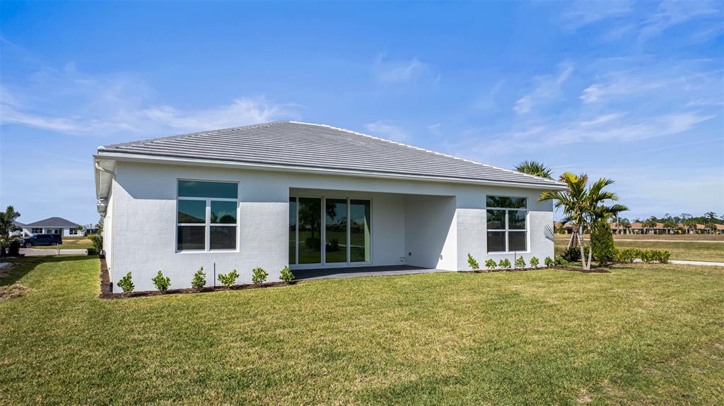 8447 Southwest Felicita Way Port St. Lucie, FL 34987 - Photo 58 of 92 a front view of a house with a garden