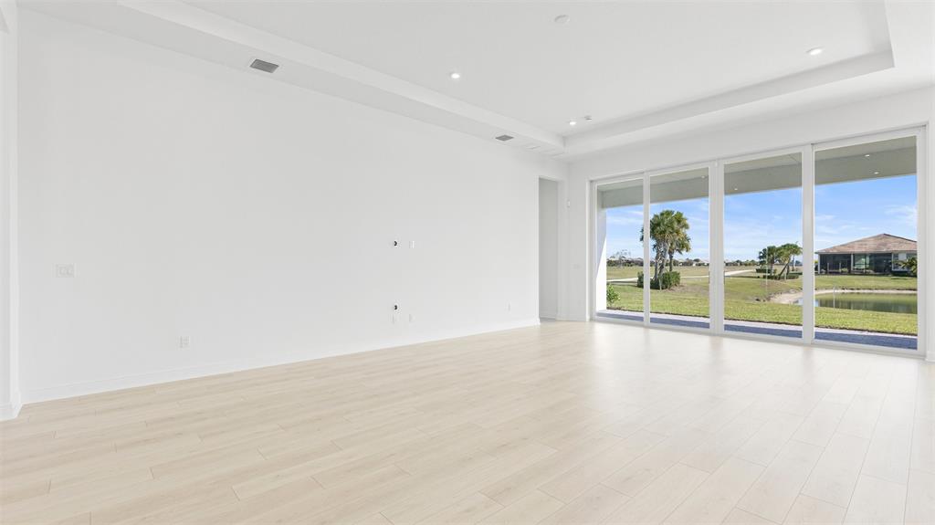 8447 Southwest Felicita Way Port St. Lucie, FL 34987 - Photo 8 of 92 an empty room with wooden floor and windows