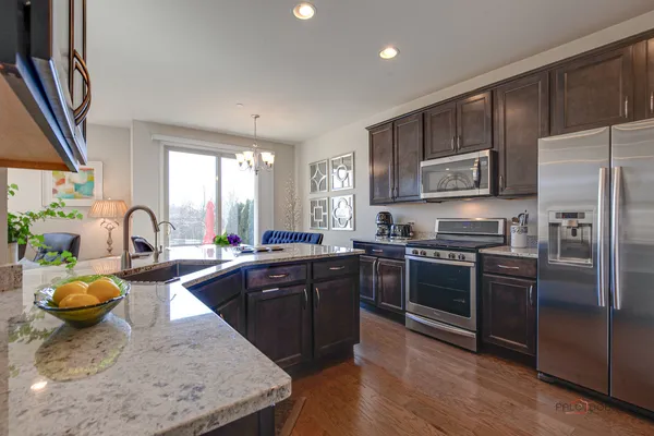 a kitchen with stainless steel appliances granite countertop a sink refrigerator and microwave
