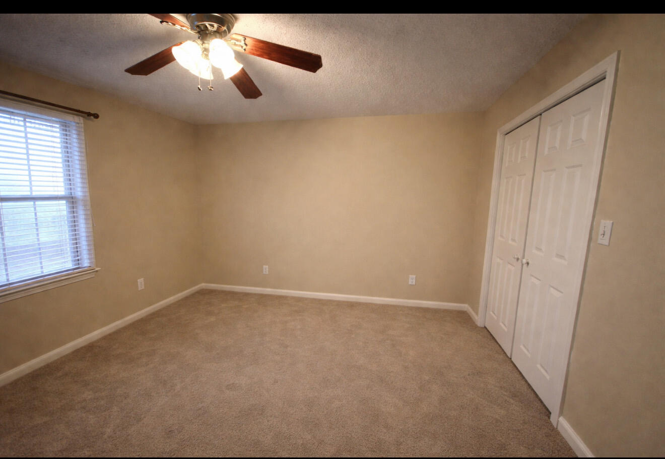 1304 1st Street Lubbock, TX 79401 - Photo 6 of 7 an empty room with a chandelier fan and windows