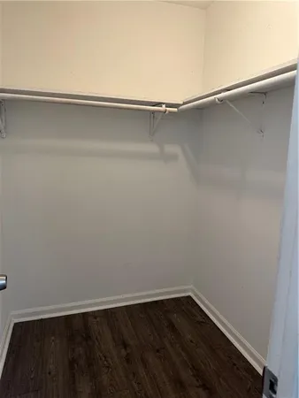 a view of an empty room and wooden floor and a window