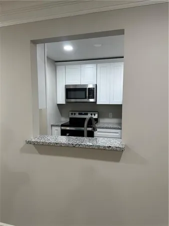 a view of kitchen with a stove and a microwave