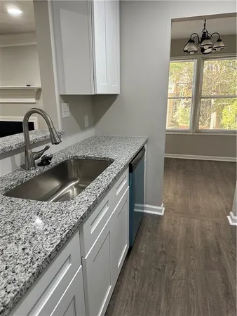 a kitchen with granite countertop a sink and a stove