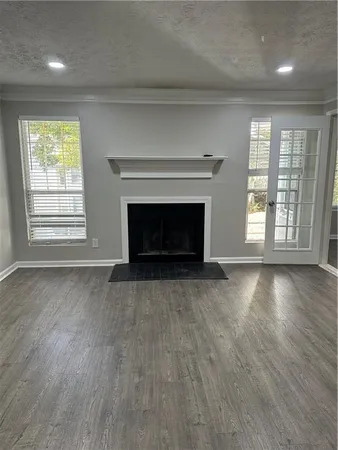 an empty room with windows and fireplace