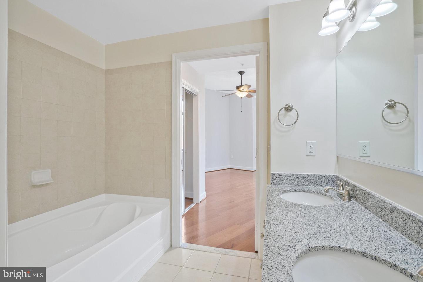 3650 South Glebe Road, Unit 638 Arlington, VA 22202 - Photo 11 of 35 a bathroom with a granite countertop sink a mirror and bathtub
