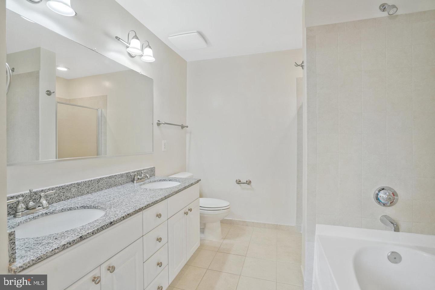 3650 South Glebe Road, Unit 638 Arlington, VA 22202 - Photo 12 of 35 a bathroom with a granite countertop sink a toilet and a mirror