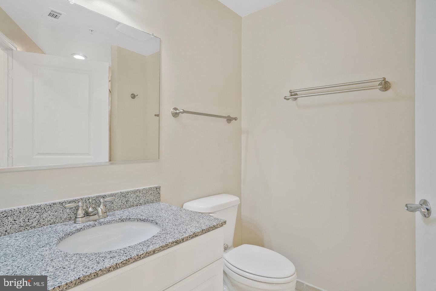 3650 South Glebe Road, Unit 638 Arlington, VA 22202 - Photo 19 of 35 a bathroom with a granite countertop sink toilet and a mirror