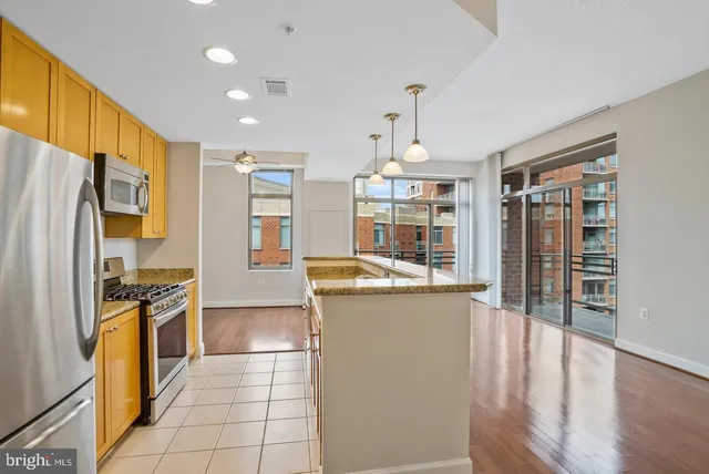 a kitchen with stainless steel appliances granite countertop a refrigerator a stove and a sink