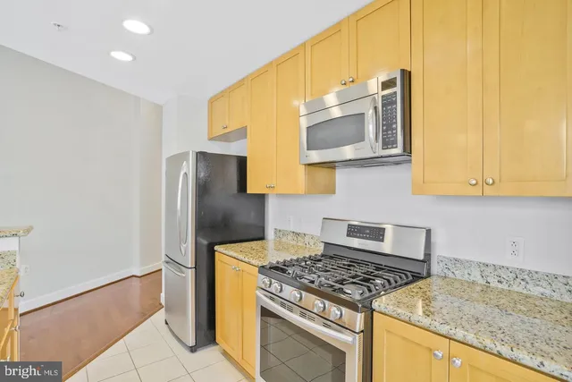 a kitchen with stainless steel appliances granite countertop a stove a refrigerator and a microwave