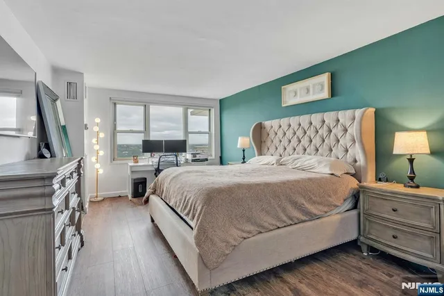 a bedroom with a bed and a night stand on dresser