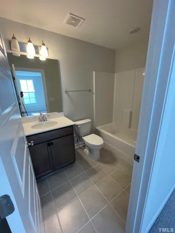 a bathroom with a double vanity sink a toilet and a mirror