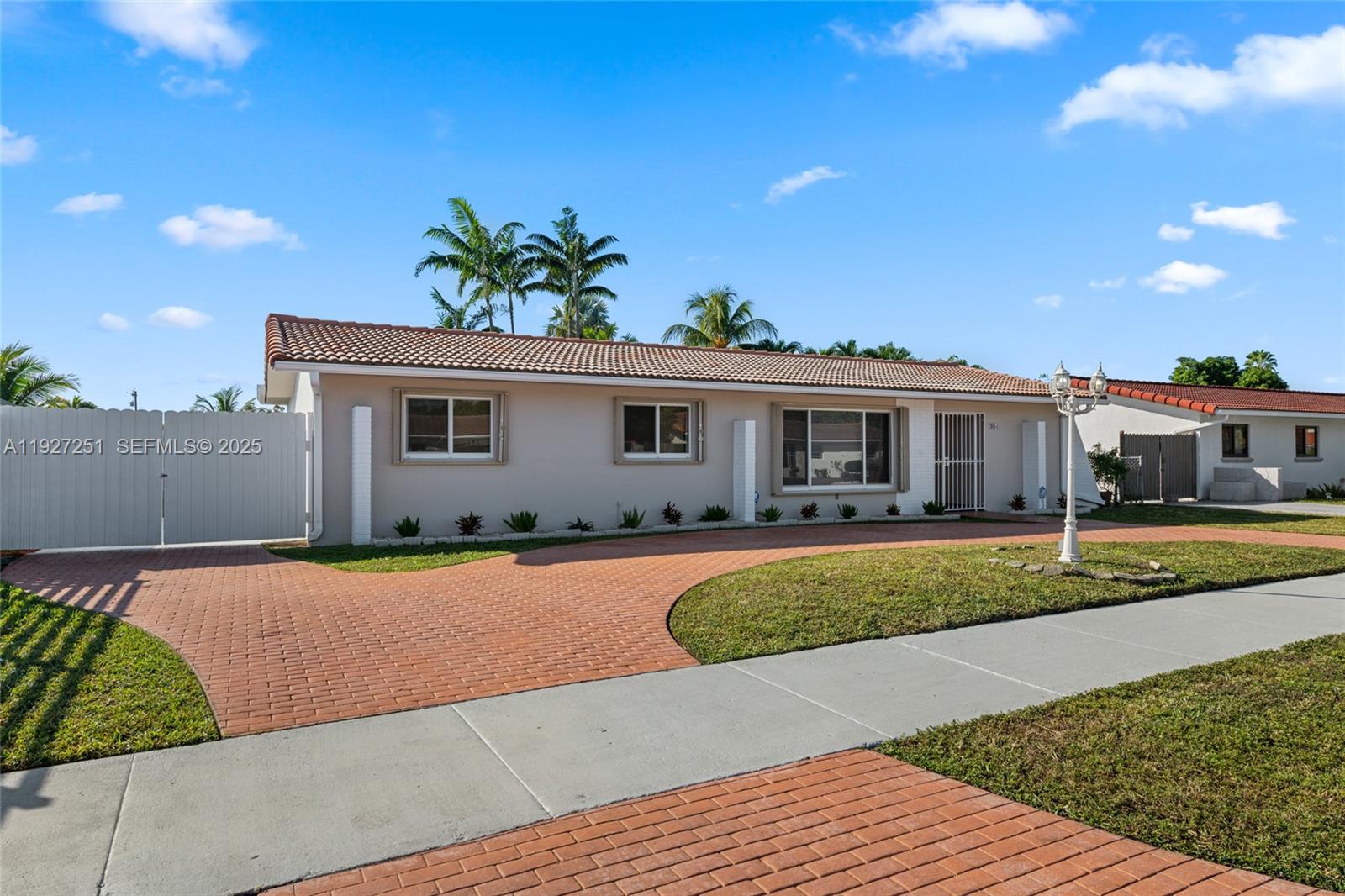 9864 Southwest 26th Terrace Miami, FL 33165 - Photo 3 of 40 a front view of a house with a yard and potted plants