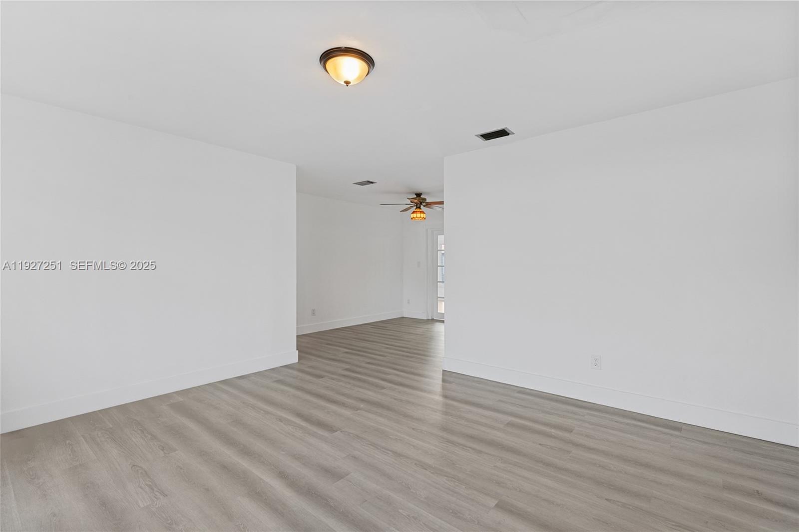 9864 Southwest 26th Terrace Miami, FL 33165 - Photo 7 of 40 a view of an empty room with wooden floor and window