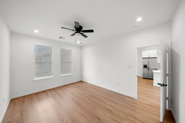 a view of empty room with wooden floor and window