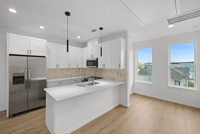 a kitchen with stainless steel appliances granite countertop a sink a refrigerator and a stove