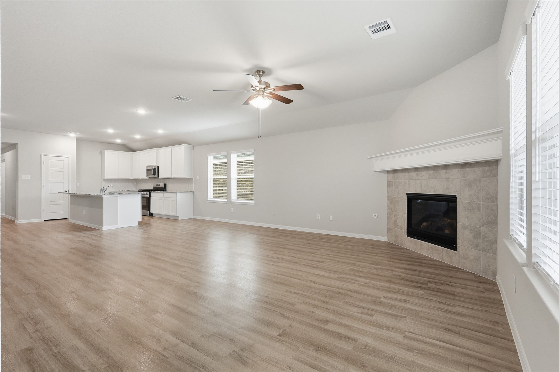 3227 Falling Brk Drive Baytown, TX 77521 - Photo 13 of 28 an empty room with wooden floor fireplace and windows
