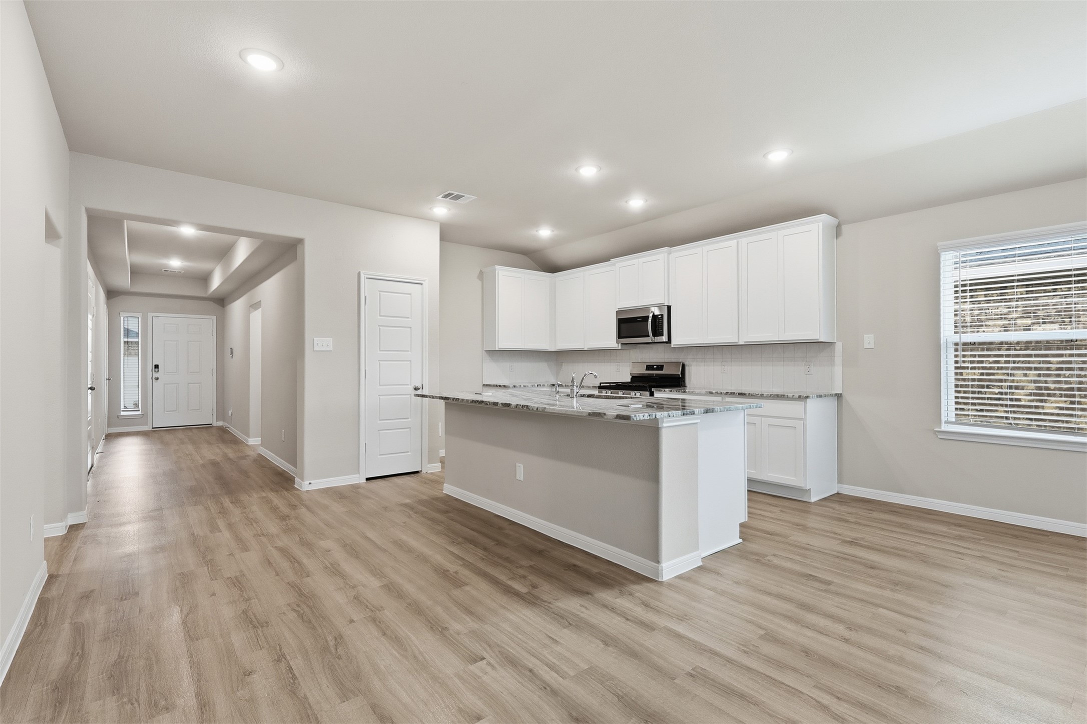 3227 Falling Brk Drive Baytown, TX 77521 - Photo 9 of 28 a kitchen with granite countertop a stove a sink and white cabinets with wooden floor