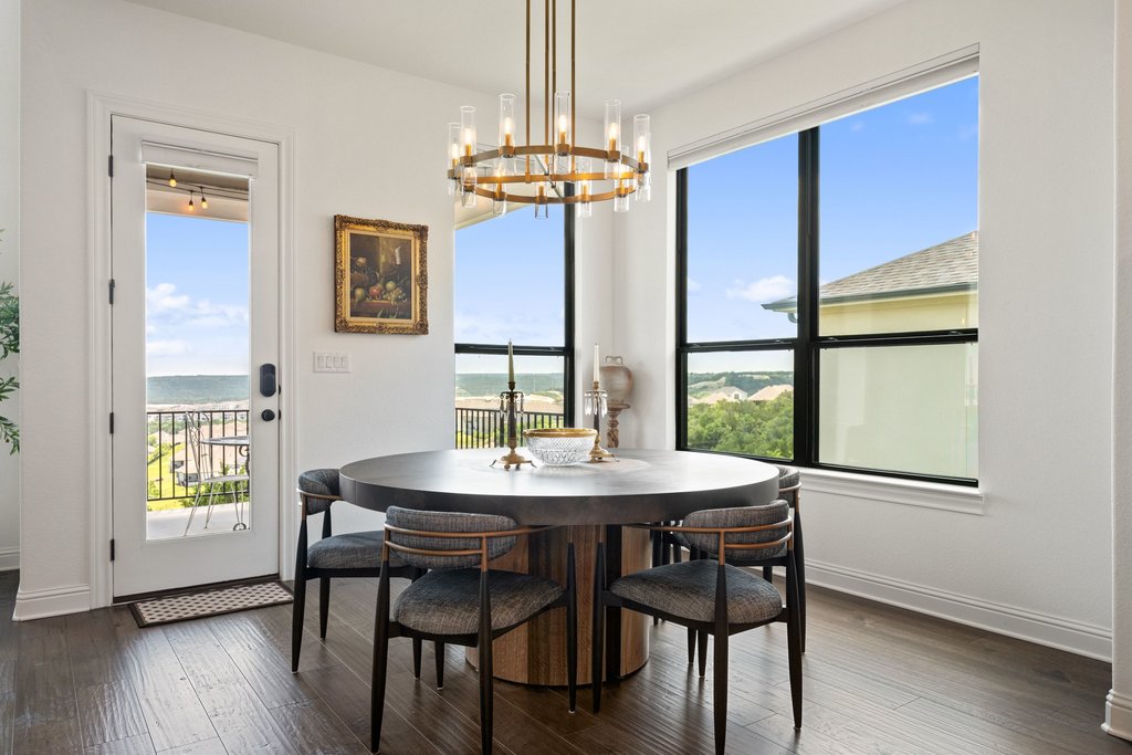 1221 Siena Sunset Road Leander, TX 78641 - Photo 15 of 39 Dining area featuring a contemporary chandelier, large picture window, and wood-finish flooring