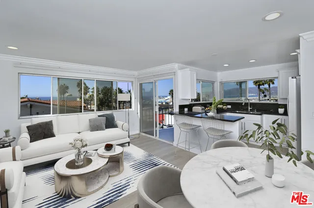 a living room with furniture and a view of kitchen