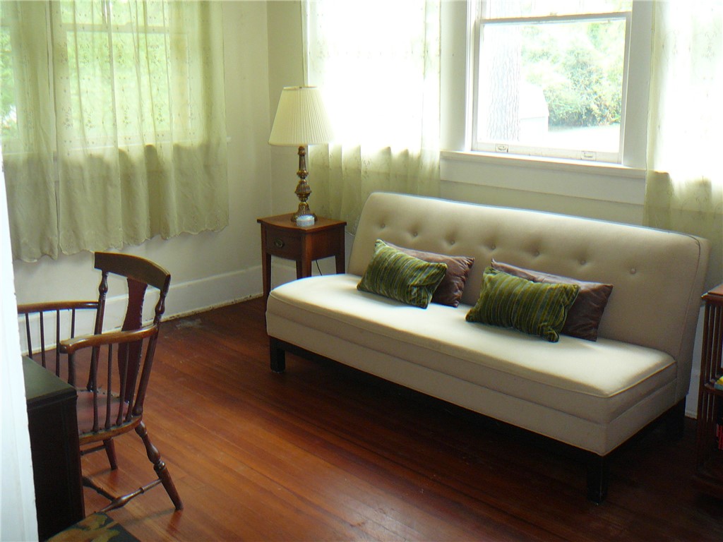 411 Central Avenue Anderson, SC 29625 - Photo 12 of 23 This bright room features rich hardwood flooring and large windows, creating an inviting atmosphere.