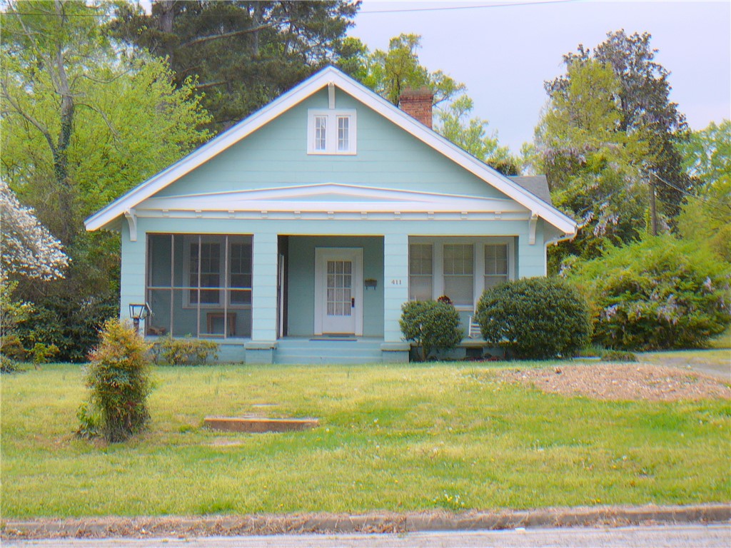 411 Central Avenue Anderson, SC 29625 - Photo 3 of 23 This charming home offers a screened porch and a lush green lawn, perfect for outdoor enjoyment.