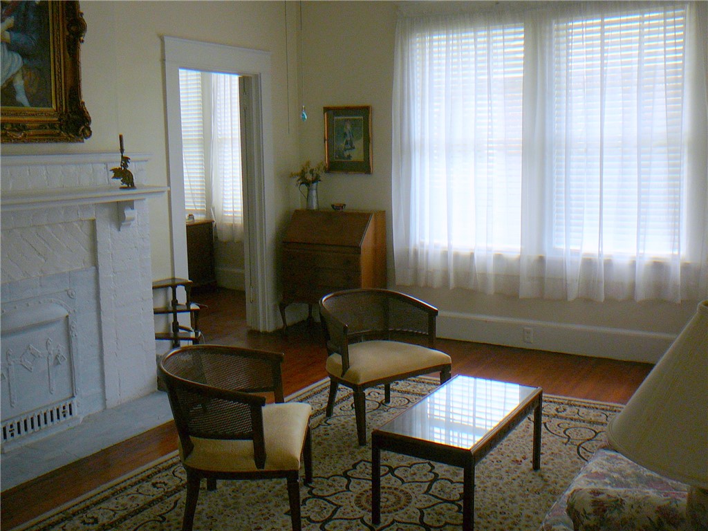411 Central Avenue Anderson, SC 29625 - Photo 6 of 23 This inviting space features a traditional fireplace and warm hardwood flooring.