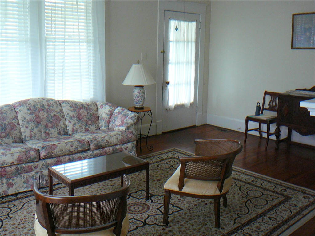 411 Central Avenue Anderson, SC 29625 - Photo 7 of 23 This inviting living room boasts warm wood flooring and ample natural light, perfect for everyday living.