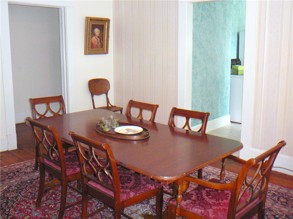 411 Central Avenue Anderson, SC 29625 - Photo 9 of 23 This classic dining area features rich wood flooring, offering an inviting space for gatherings.
