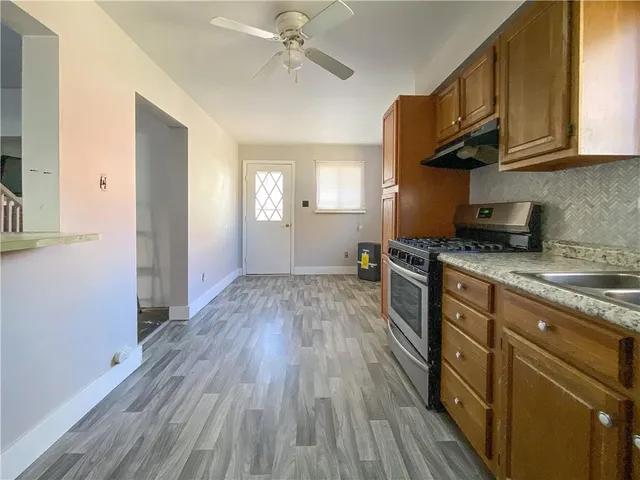 a kitchen with granite countertop wooden floors wooden cabinets and entryway